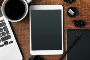 electronic gadgets and office supplies on wooden table