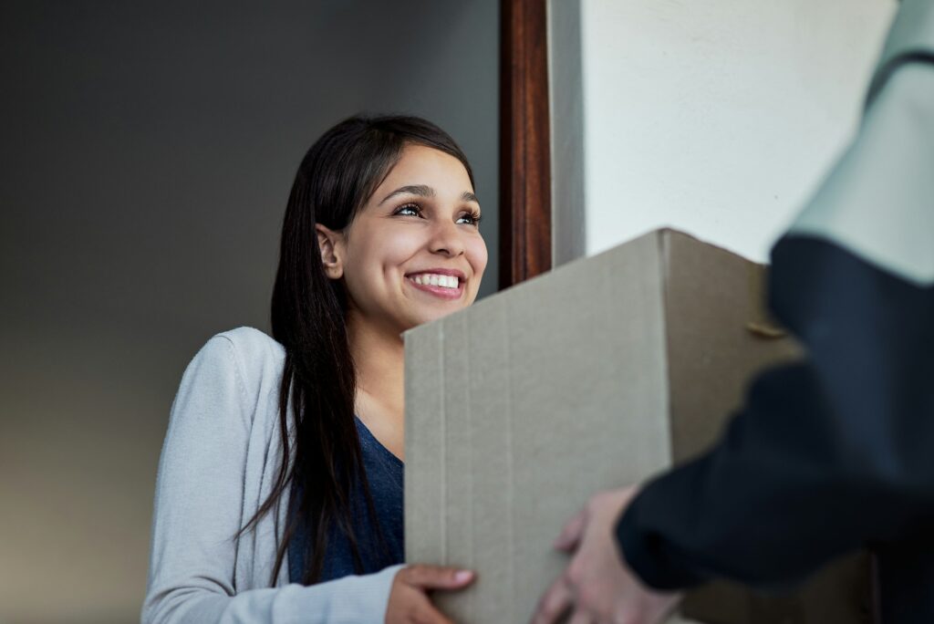 Your service never fails. Cropped shot of a young woman receiving her package from the courier.